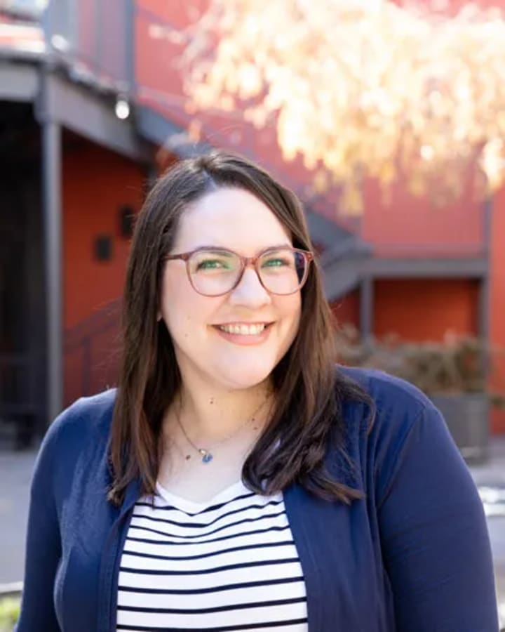 Maegan Woytek smiling outdoors in a striped shirt and navy cardigan