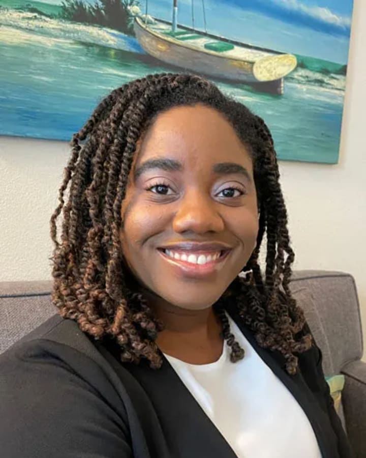 Shauna Onabajo smiling in a black blazer in a cozy office