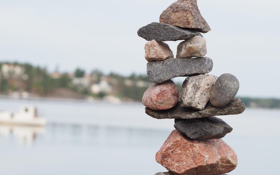 A balanced stack of stones beside a calm lake
