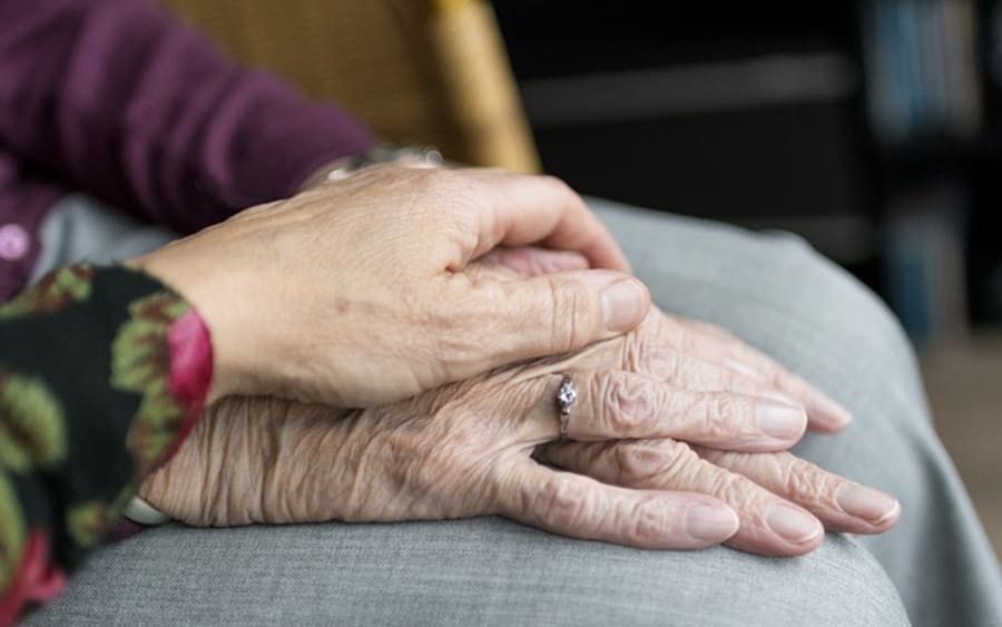 Two hands resting together, one older and one younger