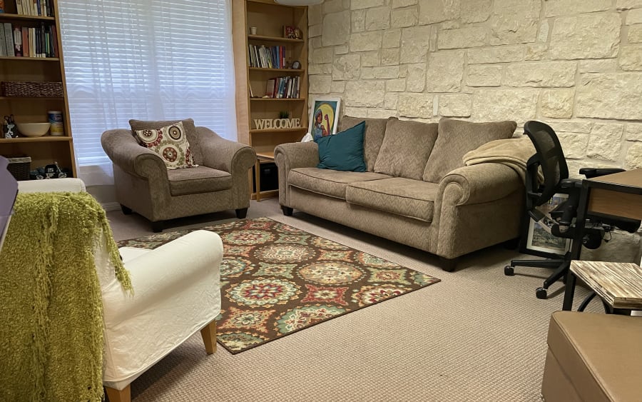 One of our therapy rooms: two couches, a woven rug, and a limestone wall