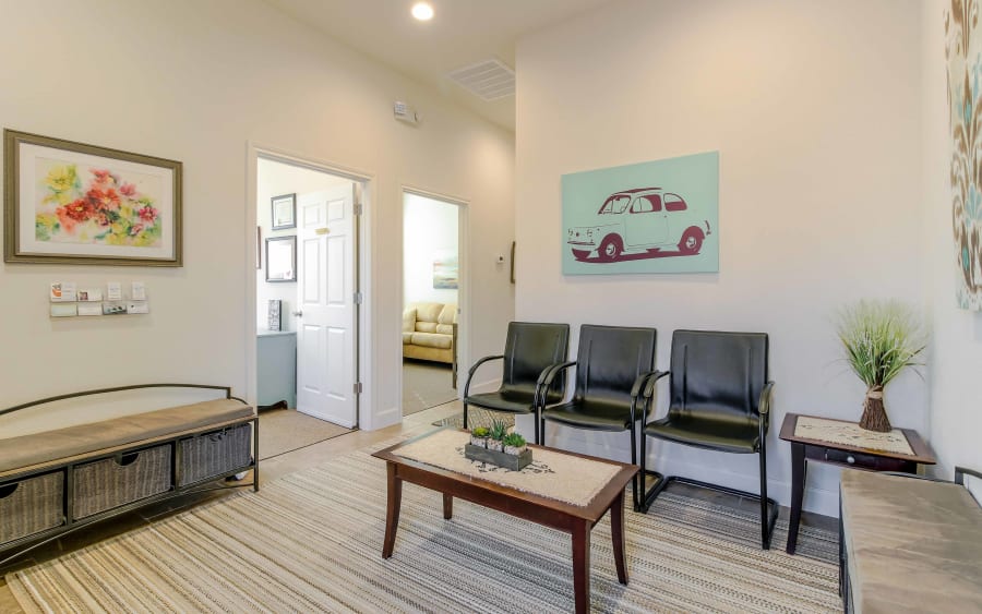 Our Round Rock waiting room: light walls, armchairs, and a vintage car painting